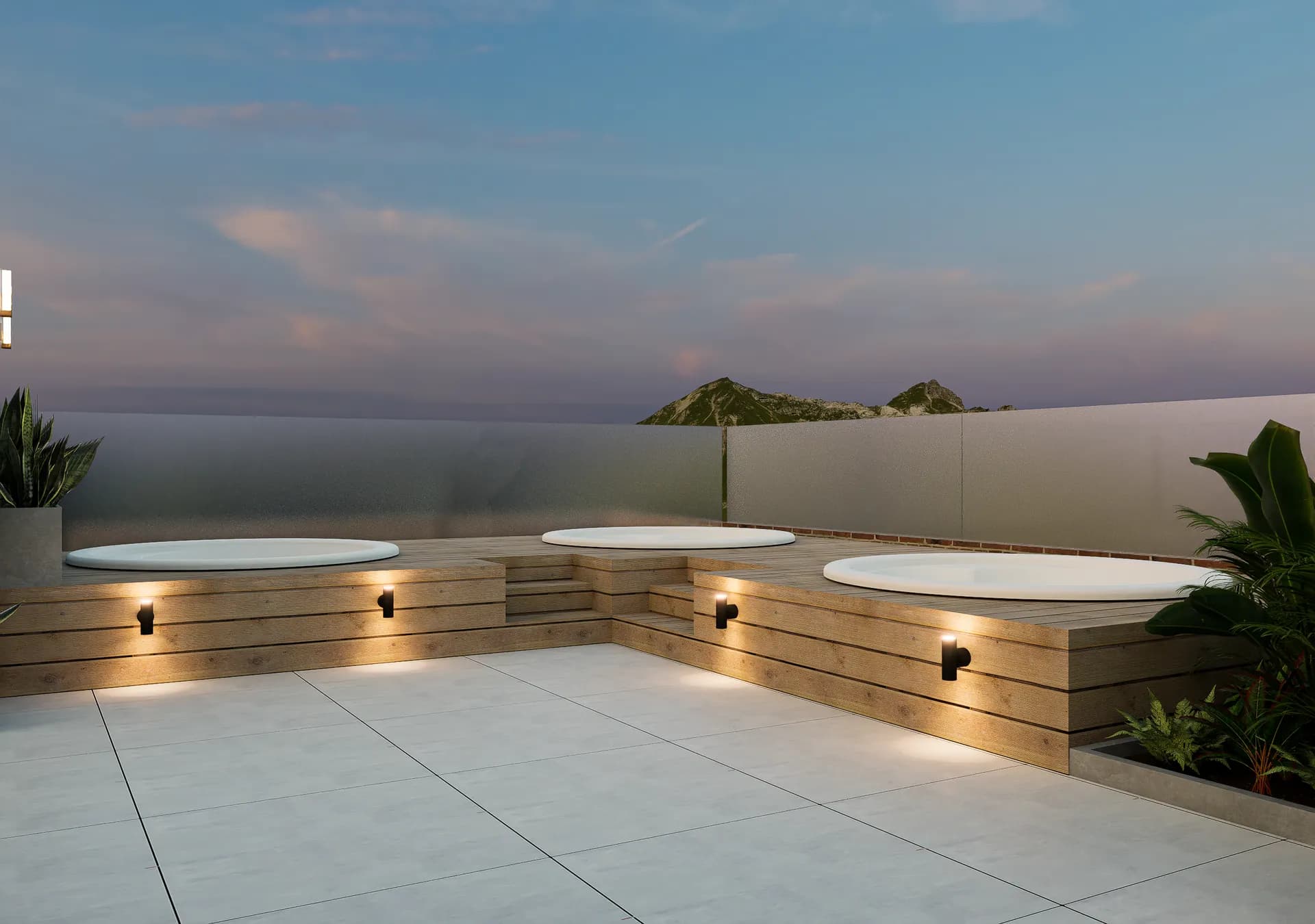Jacuzzis de la terraza al anochecer sobre plataformas de madera iluminadas.